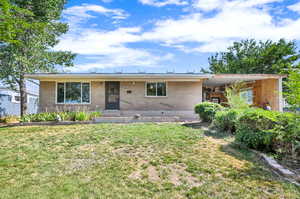 Ranch-style home featuring a front lawn