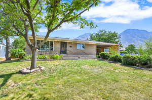 Ranch-style house featuring a mountain view and a front yard