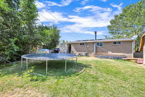 View of yard featuring central air condition unit and a trampoline