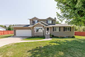 View of front facade with a garage and a front lawn