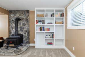 Carpeted living room featuring built in shelves and a wood stove