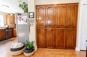 Kitchen with dishwasher, light wood-type flooring, and white refrigerator