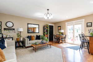 Living room with light hardwood / wood-style flooring and a chandelier