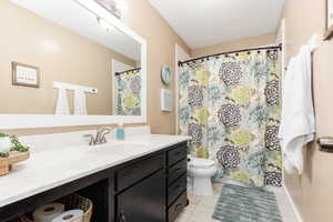 Bathroom featuring tile patterned flooring, toilet, and vanity