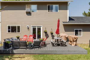 Rear view of property with an outdoor living space and a wooden deck