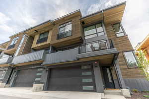 View of front of home featuring a balcony and a garage