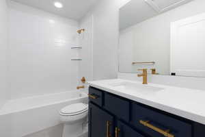 Full bathroom featuring vanity, tiled shower / bath, tile patterned flooring, and toilet