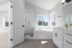 Bathroom with independent shower and bath, vanity, lofted ceiling, and tile patterned flooring