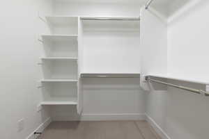 Walk in closet with light colored carpet