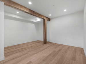 Basement with light hardwood / wood-style flooring