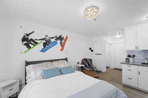 Bedroom with an inviting chandelier and light hardwood / wood-style floors