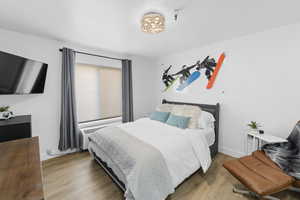 Bedroom with an inviting chandelier and wood-type flooring