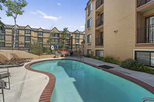 View of swimming pool with a patio area and a grill