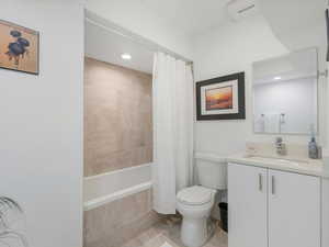 Full bathroom with vanity, tile patterned flooring, toilet, and shower / bath combination with curtain