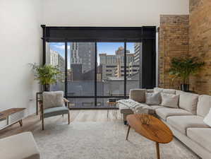 Living room with wood-type flooring and brick wall