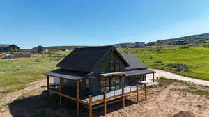 Rear view of house with a rural view and covered porch