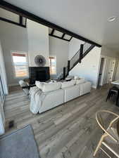 Living room featuring hardwood / wood-style floors, a fireplace, and high vaulted ceiling