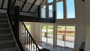 Stairs featuring light hardwood / wood-style flooring and a high ceiling