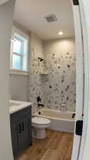 Full bathroom with bathing tub / shower combination, vanity, and hardwood / wood-style floors