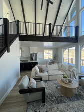 Living room with plenty of natural light, high vaulted ceiling, and beamed ceiling