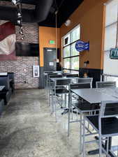 Dining room with concrete flooring and brick wall