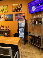 Bar featuring concrete floors, wine cooler, and wood counters