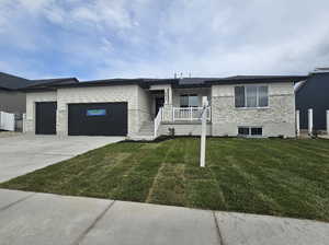 View of front facade with a front lawn and a garage