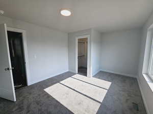 Unfurnished bedroom with a closet, carpet floors, and a walk in closet