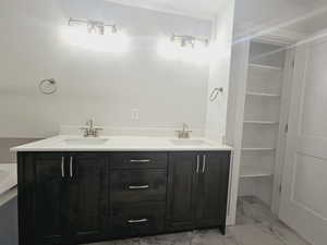 Bathroom with a tub, dual vanity, and tile patterned flooring