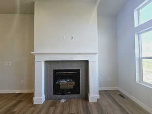 Unfurnished living room with a tile fireplace and hardwood / wood-style flooring