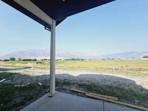 View of patio / terrace featuring a mountain view and a rural view