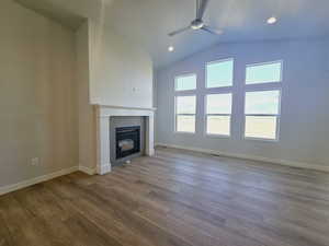 Unfurnished living room with a tile fireplace, ceiling fan, and hardwood / wood-style floors