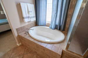 Owner Bathroom #2 with tiled bath and tile patterned floors