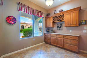 Kitchen with light tile patterned floors & rustic maple buffet  and wine rack