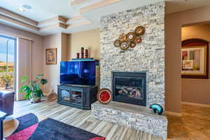 Tiled living room featuring a stone fireplace