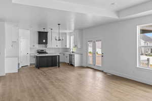 Kitchen featuring a center island, white cabinets, light wood-type flooring, and stainless steel appliances