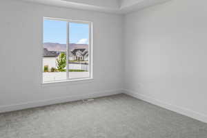 Empty room with carpet floors and a healthy amount of sunlight