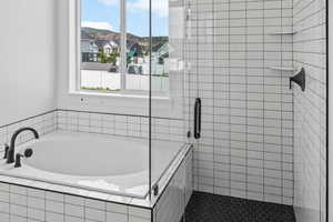 Bathroom with a relaxing tiled tub and tile patterned floors