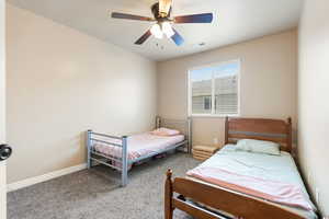 Carpeted bedroom featuring ceiling fan