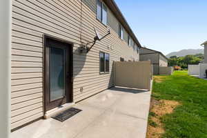 View of side of home featuring a lawn and a patio area