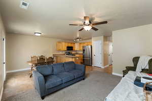 Living room with light tile patterned flooring and ceiling fan