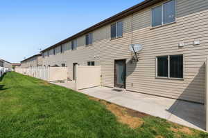 Rear view of property with a patio area and a yard