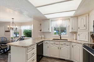 Kitchen featuring dark hardwood / wood-style floors, sink, kitchen peninsula, and a textured ceiling