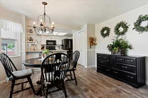 Dining space featuring hardwood / wood-style flooring and an inviting chandelier