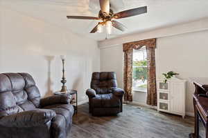 Living area with wood-type flooring and ceiling fan