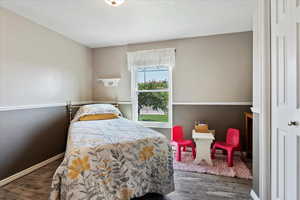 Bedroom with dark hardwood / wood-style flooring