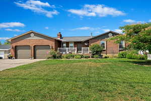 Single story home featuring a garage and a front yard