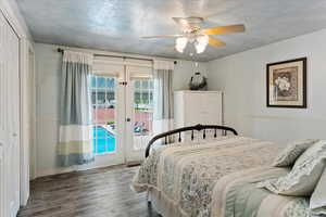 Bedroom with french doors, dark hardwood / wood-style flooring, access to exterior, ceiling fan, and a closet