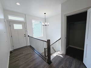 Entryway featuring dark wood-type flooring and a notable chandelier