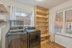 Washroom featuring light hardwood / wood-style floors and washer and dryer